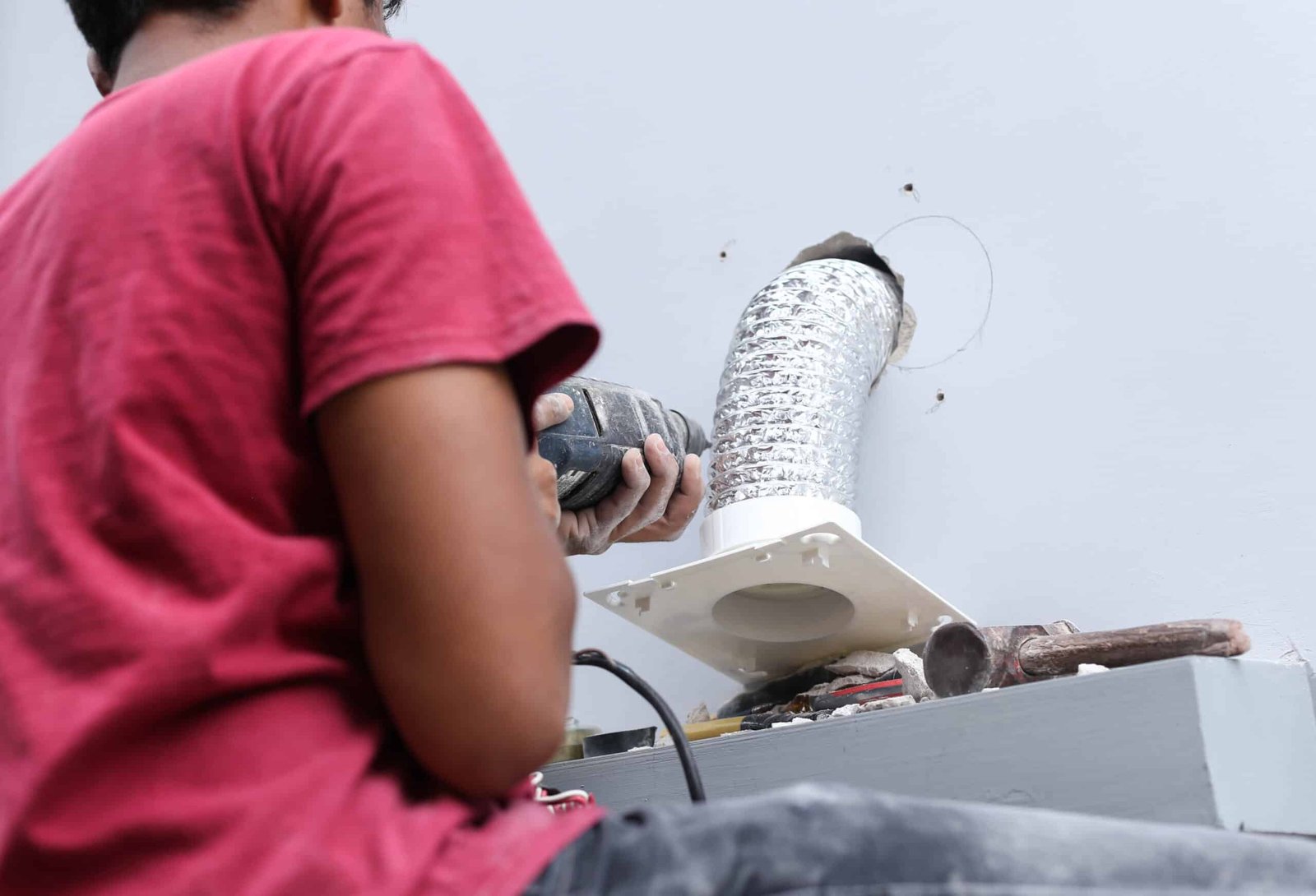 Persona trabajando junto a una instalación de ventilación industrial